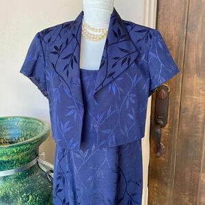 Two piece navy dress features bolero jacket over sleeveless dress size 16
